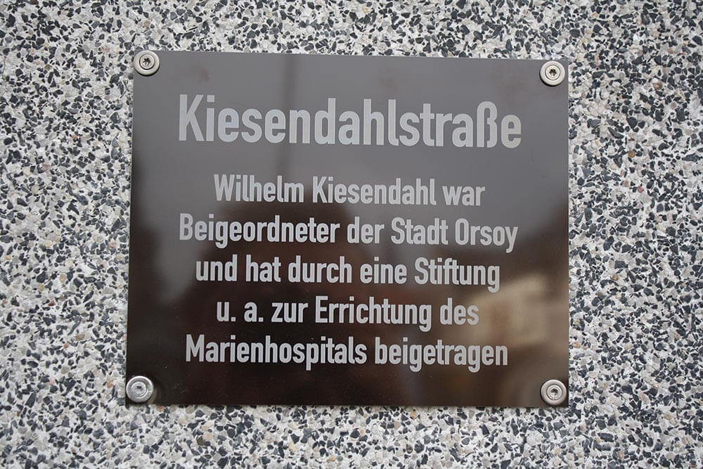 Orsoy, Straßenschilder, Kiesendahlstraße: Wilhelm Kiesendahl war Beigeordneter der Stadt Orsoy und hat durch eine Stiftung u.a. zur Errichtung des Marienhospitals beigetragen